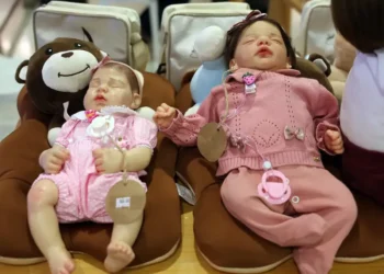 Bonecas realistas tipo bebê reborn expostas em almofadas de pelúcia
