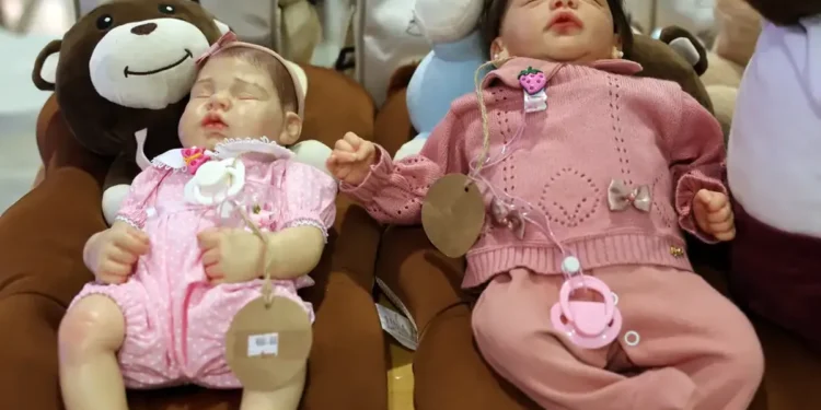 Bonecas realistas tipo bebê reborn expostas em almofadas de pelúcia