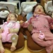 Bonecas realistas tipo bebê reborn expostas em almofadas de pelúcia