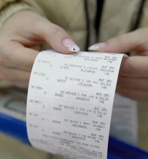 Mãos femininas segurando um recibo longo de compra, representando o registro detalhado para concorrer na Nota Premiada MS.