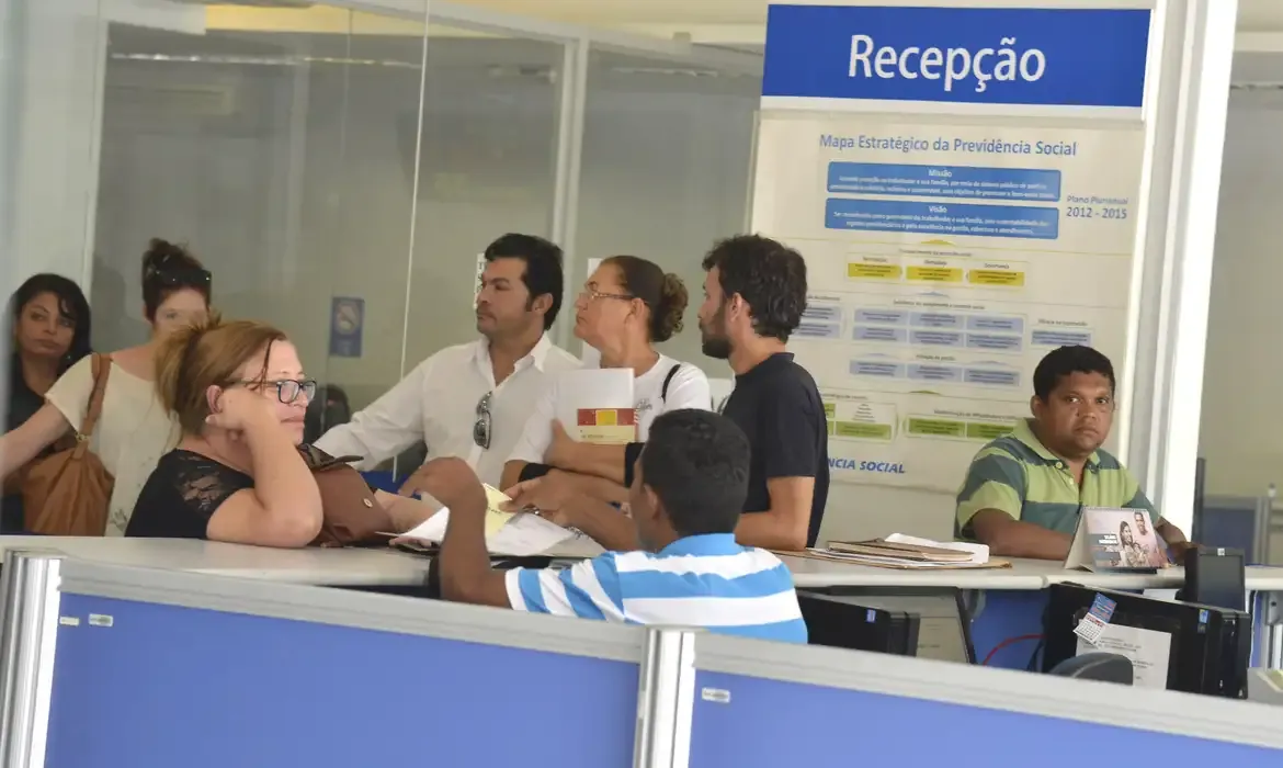Pessoas aguardam atendimento na recepção de uma agência do INSS
