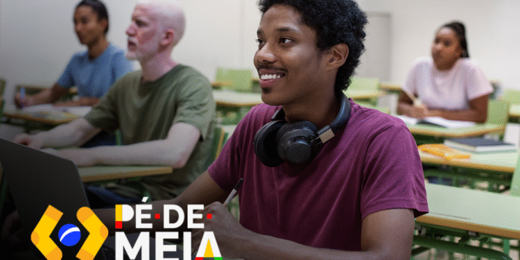 Estudante sorrindo enquanto usa um laptop em sala de aula, com outros alunos ao fundo, representando a temática do benefício educacional do Pé-de-Meia.