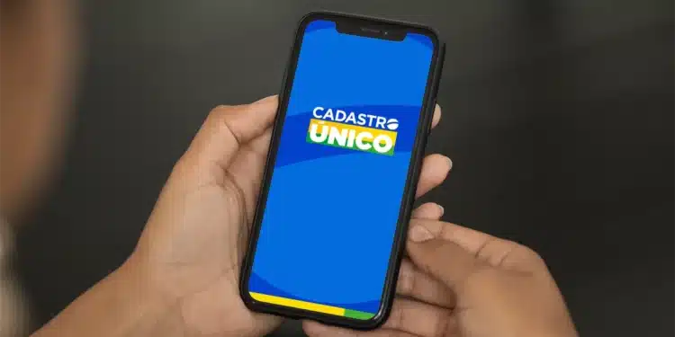 Imagem mostrando o logo do CadÚnico em um celular, relacionado ao programa 'Novo Bolsa Família' que promete auxílio extra para inscritos.