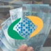 Cédulas de 100 reais brasileiras em mãos com o logo do PIS/Pasep sobreposto, representando o resgate de valores esquecidos.
