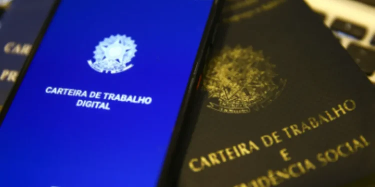 Carteira de Trabalho Digital e física sobre teclado, representando benefícios trabalhistas e a possibilidade de solicitar apoio financeiro em caso de perda de emprego.