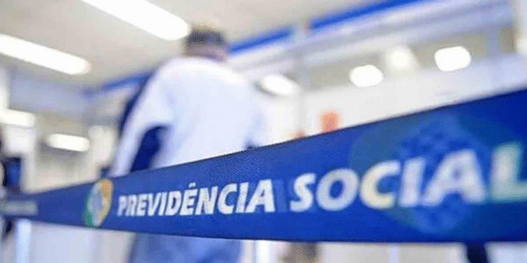 Fila de atendimento no INSS, com faixa destacando 'Previdência Social