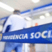 Fila de atendimento no INSS, com faixa destacando 'Previdência Social