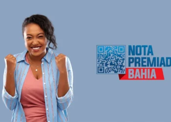 Mulher sorridente com os braços levantados e punhos fechados, comemorando, com a logo da Nota Premiada Bahia ao lado e um QR code.
