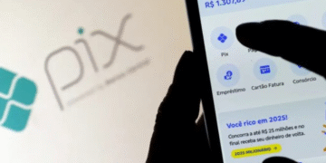 Imagem ilustrativa de uma pessoa acessando o Pix no celular, com destaque para o logotipo do Pix ao fundo, relacionado a um alerta sobre golpes.