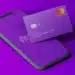 Cartão Nubank roxo com o logo da Mastercard e smartphone exibindo o aplicativo