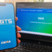 Aplicativo e site do FGTS abertos em celular e notebook