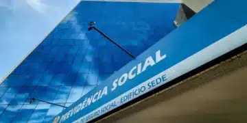 Fachada do edifício sede do INSS, destacando o logotipo e o nome 'Previdência Social', com um céu azul ao fundo.