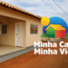 Imagem do programa Minha Casa Minha Vida com casas populares em uma rua de bairro.
