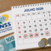 Calendário de julho 2026 com datas 27, 28, 29, 30 e 31 circuladas, cartão INSS e dinheiro ao lado