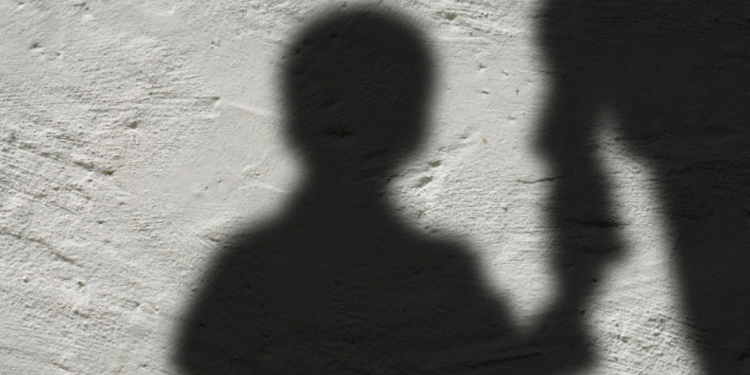 Silhueta de uma criança segurando a mão de um adulto, representando o auxílio para órfãos de feminicídio.