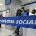 Fila de pessoas em uma agência do INSS aguardando atendimento para serviços de benefícios previdenciários.