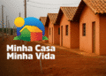 Logo do programa Minha Casa Minha Vida com imagem de casas populares e fundo com céu e postes.