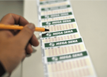 Papel da Mega-Sena com números sendo marcados, tema sobre prêmio de R$ 76 milhões.