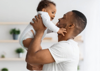 Pai segurando bebê com carinho, ilustrando a licença-paternidade de 15 dias.