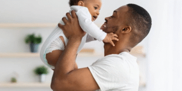 Pai segurando bebê com carinho, ilustrando a licença-paternidade de 15 dias.