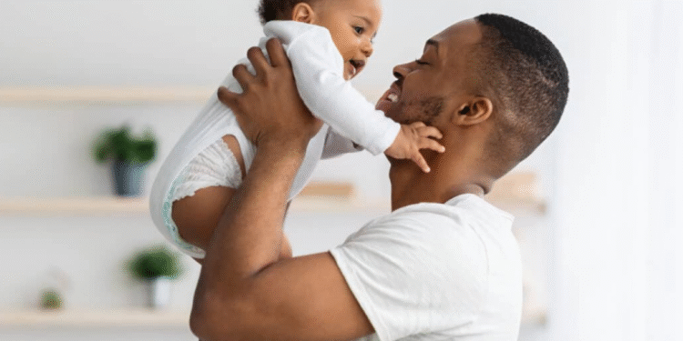 Pai segurando bebê com carinho, ilustrando a licença-paternidade de 15 dias.