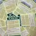 Volantes da Mega-Sena espalhados sobre a mesa, representando apostas