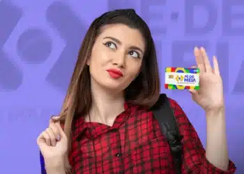 Estudante segurando o cartão do programa Pé-de-Meia do Governo Federal