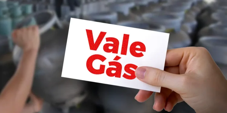 Cartão do Vale Gás Social sendo segurado, com fundo de botijões de gás.