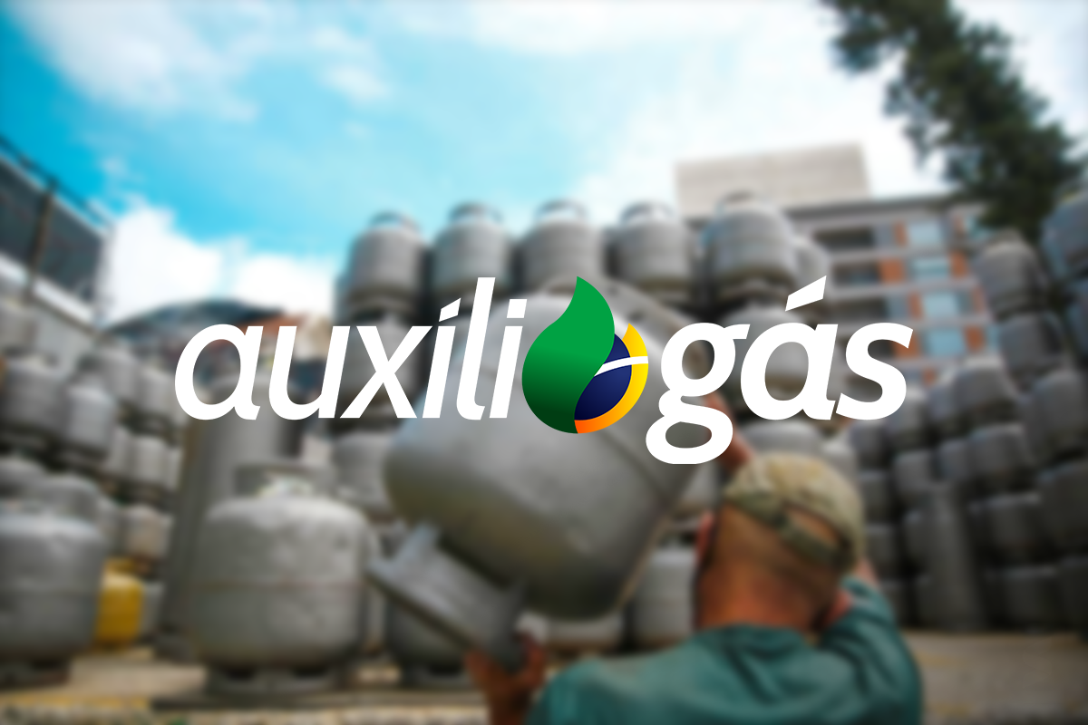 Homem carrega botijão de gás com logo do Auxílio Gás em destaque, pilhas de botijões ao fundo.