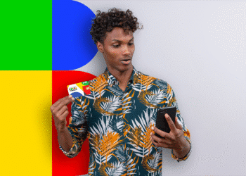 Homem segurando cartão do Bolsa Família enquanto olha para o celular, em fundo colorido, simbolizando informações sobre pagamento extra.