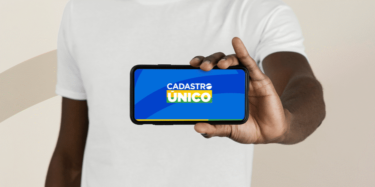 Pessoa segurando um celular com a tela exibindo o aplicativo do Cadastro Único