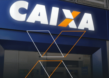Fachada da agência da Caixa Econômica Federal, destacando o logotipo iluminado em azul e laranja.