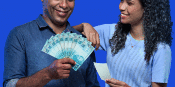 Casal sorridente segurando cédulas de R$ 100 e cupom fiscal