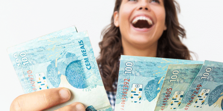Mulher sorrindo segurando cédulas de 100 reais representando aumento do salário mínimo em 2026