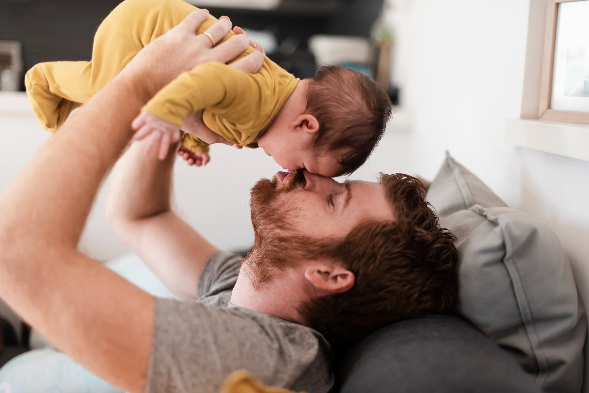 Pai segurando seu bebê nos braços, destacando o impacto positivo da licença-paternidade de 30 dias para fortalecer o vínculo familiar e o desenvolvimento da criança.