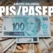 Nota de 100 reais sobre outras cédulas de reais, representando o pagamento do abono salarial PIS/Pasep 2025.