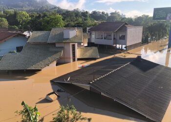 Imagem de um bairro inundado com várias casa submersas pela água.