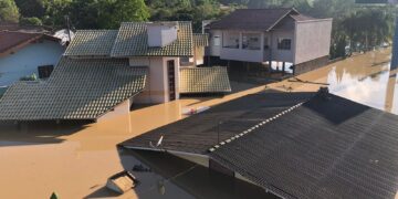 Imagem de um bairro inundado com várias casa submersas pela água.