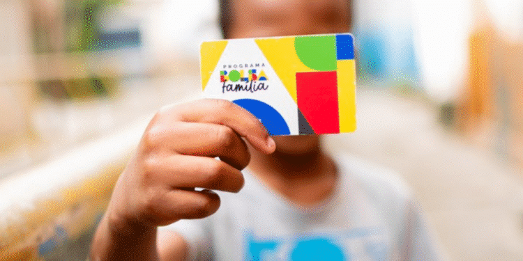 Criança segurando cartão do Bolsa Família com elementos gráficos coloridos.