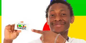 "Homem mostrando cartão do Programa Bolsa Família, com fundo colorido. Imagem relacionada ao pagamento de agosto.