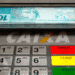 Caixa eletrônico dispensando cédulas de R$ 100. Depósitos de R$ 2.800 para brasileiros com CPF final 0 a 9 em agosto.