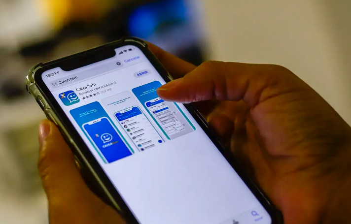 Pessoa usando o app Caixa Tem no celular para acessar o Pé‑de‑Meia