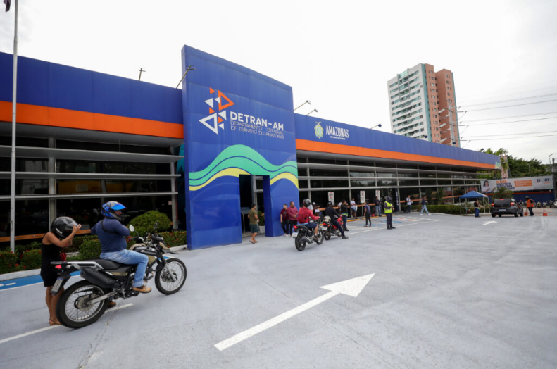 Imagem do Detran AM com pessoas e motos na frente, relacionado à nova convocação que beneficia 10 mil pessoas.