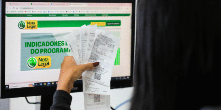 Pessoa verificando resultados no programa Nota Legal com diversos cupons fiscais