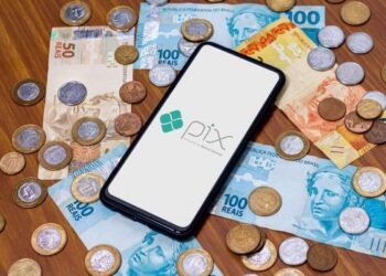 Imagem representando o sistema de pagamentos Pix, com notas de dinheiro e moedas brasileiras, simbolizando o abono salarial PIS/Pasep de 2025.