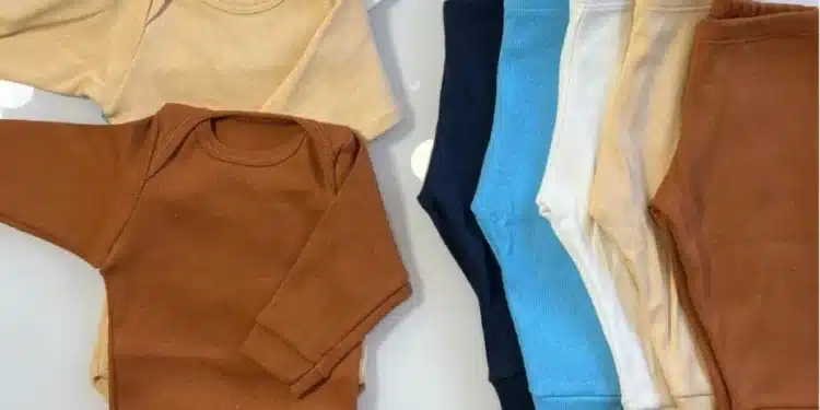 Kit enxoval para gestantes com conjuntos de roupas para bebê em várias cores, incluindo marrom, bege e azul claro.