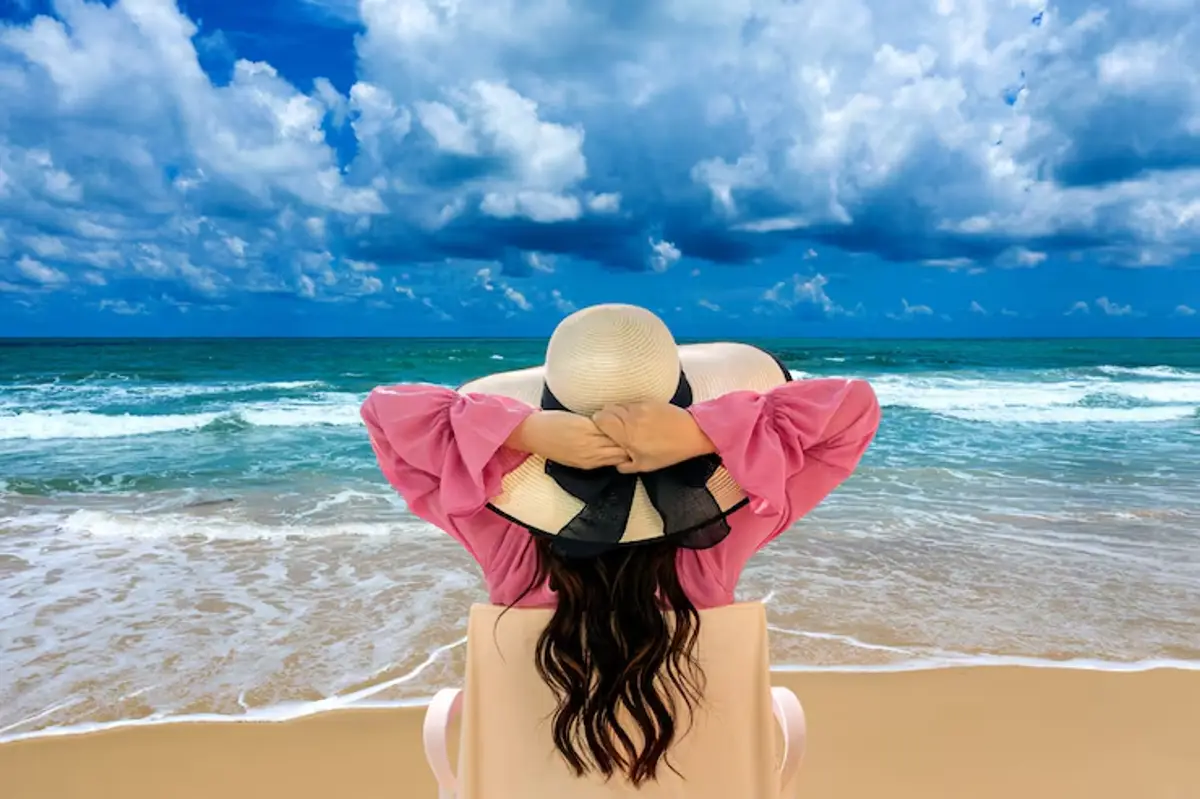 Mulher relaxando na praia com céu nublado e ondas suaves