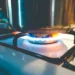 Chama de gás acesa com panela em fogão de cozinha, representando o benefício do gás de cozinha gratuito.
