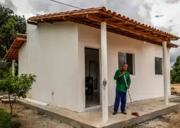 Homem em frente à casa simples recém-construída no interior da Bahia
