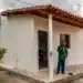 Homem em frente à casa simples recém-construída no interior da Bahia